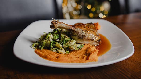 Roasted duck leg with Brussels sprouts and sweet potato purée at The Bistro at Gervasi Vineyard, a fine dining experience in Canton, Ohio.