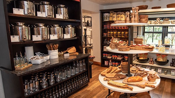Gourmet gift section at The Marketplace at Gervasi Vineyard showcasing flavored olive oils, artisan wood boards, and culinary essentials.