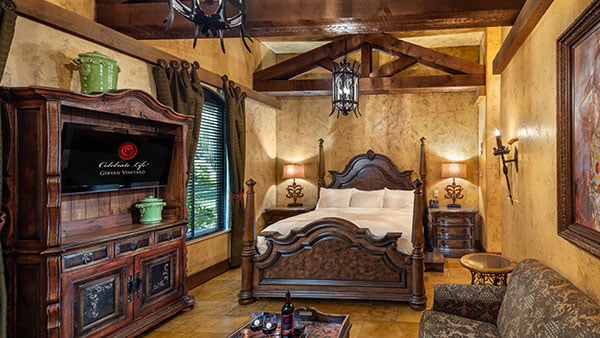 Luxurious Tuscan-inspired villa suite at Gervasi Vineyard with a king bed, wood furniture, and warm lighting.