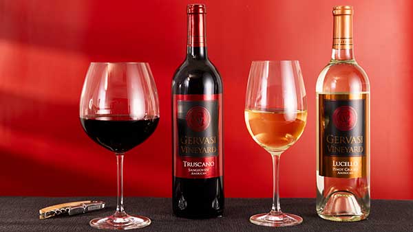 Gervasi Vineyard Truscano Sangiovese and Lucello Pinot Grigio wines displayed with filled glasses against a red backdrop
